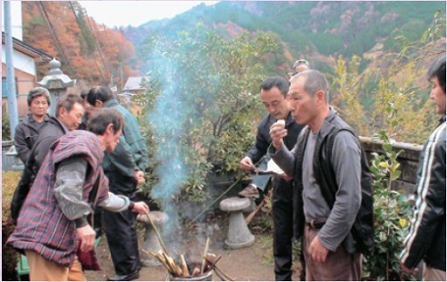 図3 包丁に刺してわたされた餅を食べるしぐさをする